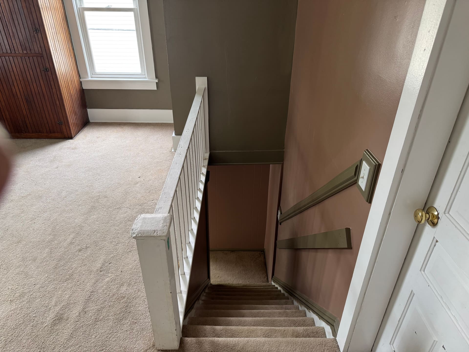 Stairwell looking up toward the landing before repaint, dated paint and trim